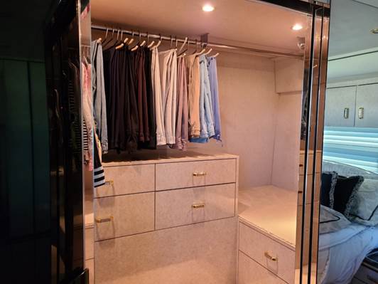 A closet with clothes in it

Description automatically generated