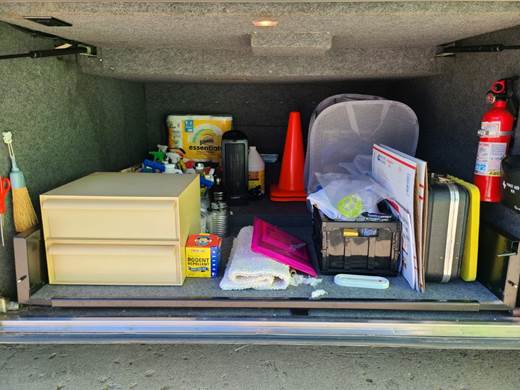 A trunk of a car with tools and equipment

Description automatically generated