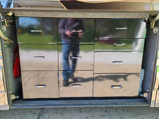 A mirrored drawer with a person in the back

Description automatically generated