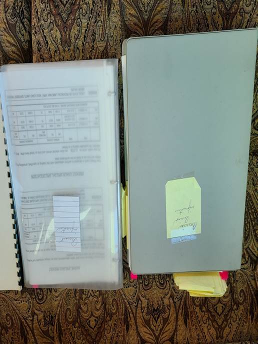 A binder with papers and a note

Description automatically generated with medium confidence